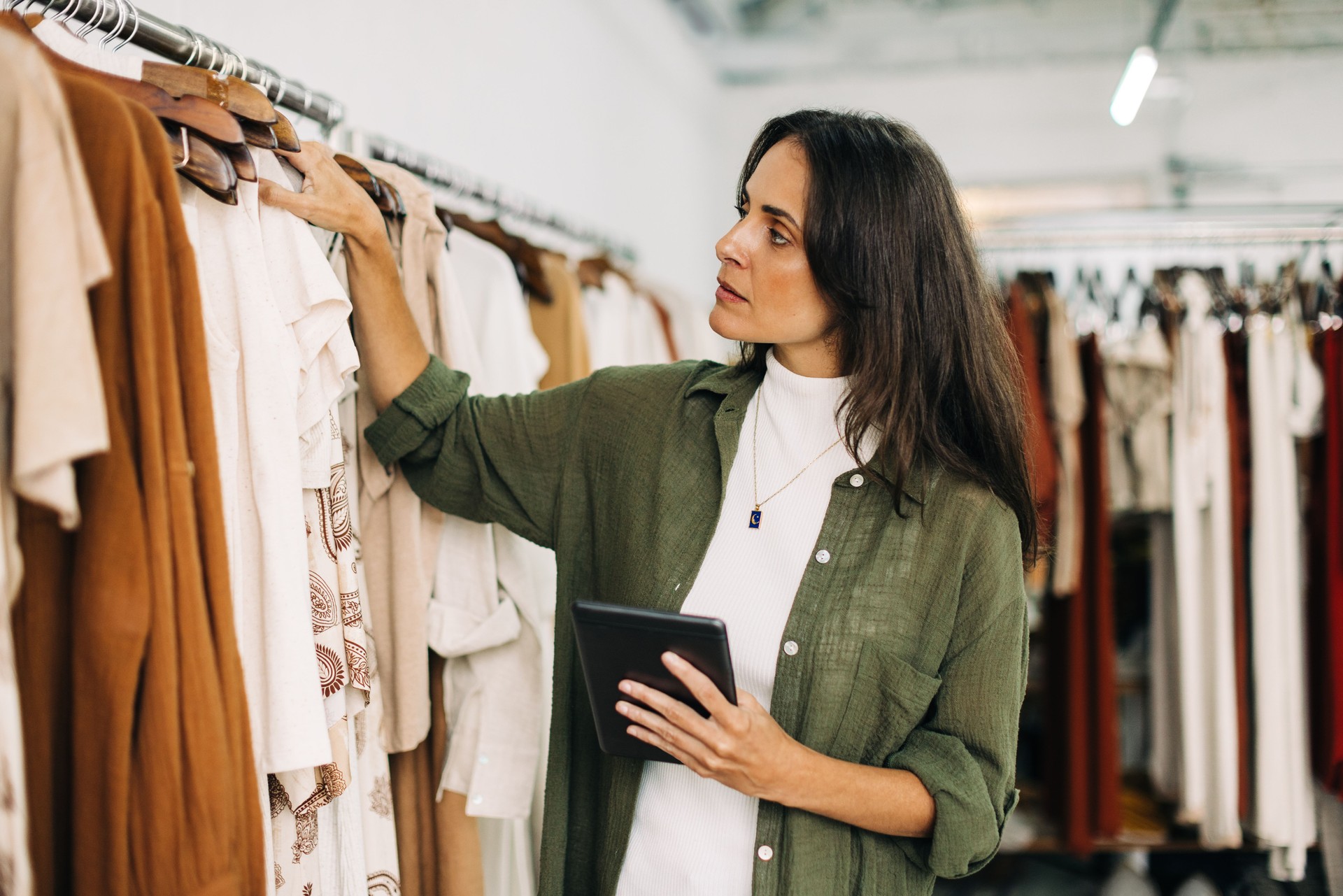 Clothing store owner doing a stock take with a tablet